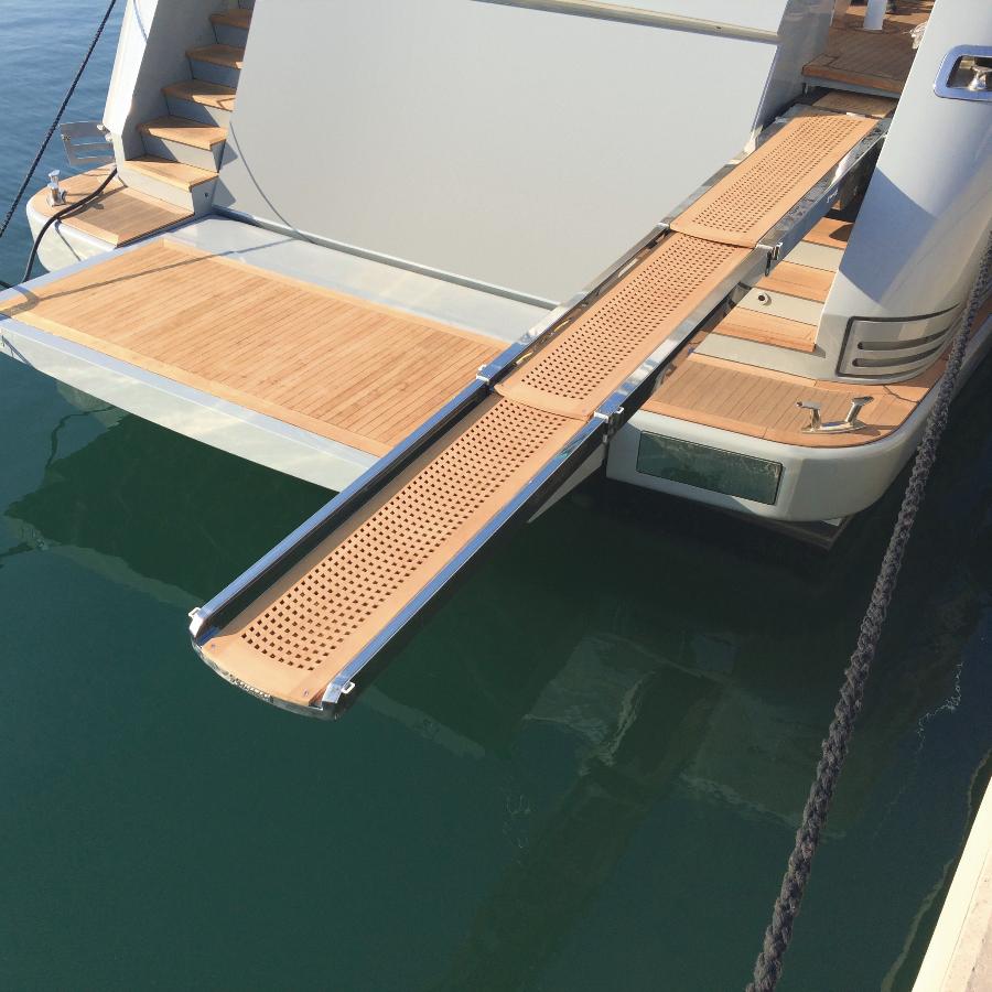 Piattaforma retrattile con azionamento idraulico, caratterizzata da struttura e corrimano in acciaio inossidabile e superficie di calpestio realizzata in legno di teak 